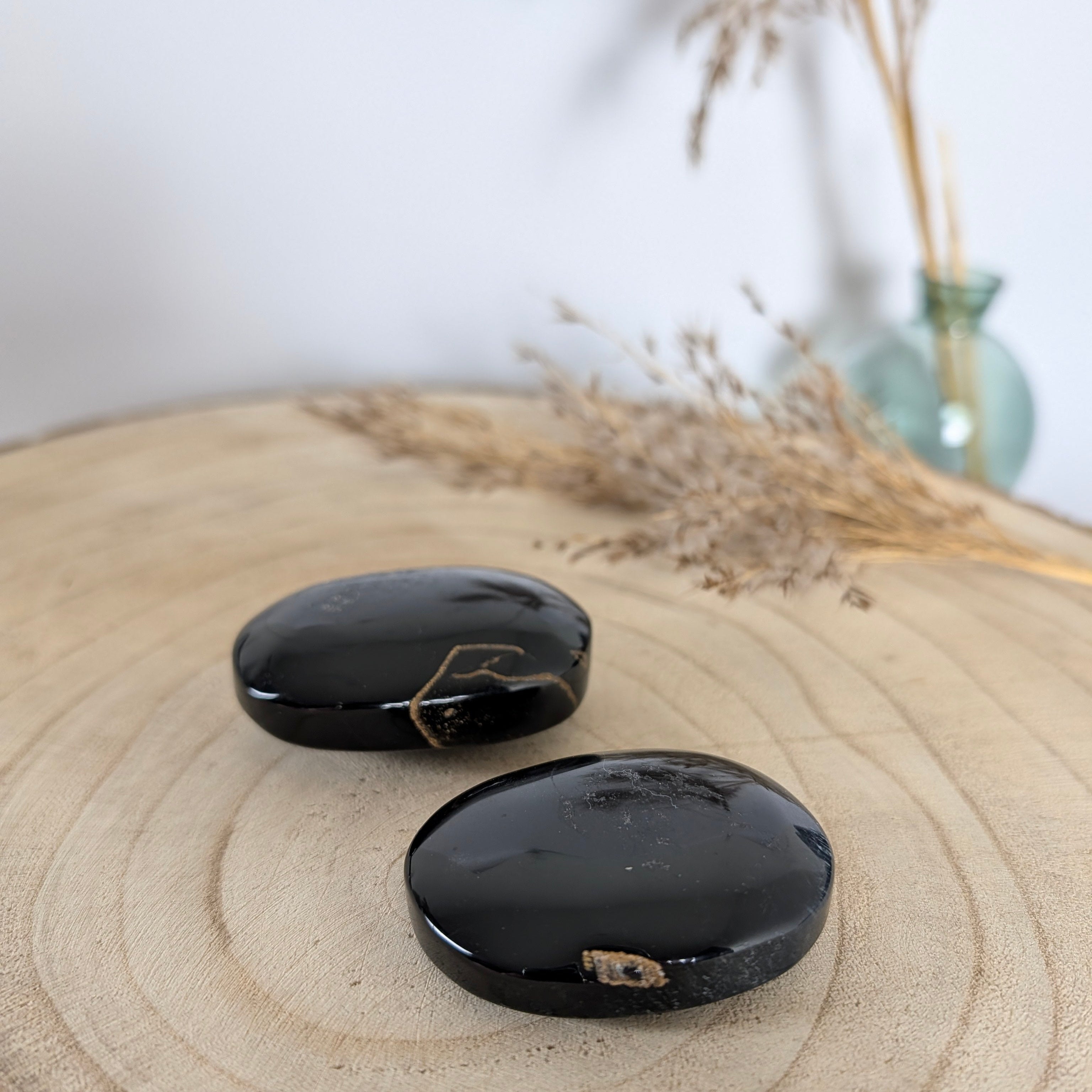 Blauwe tijgeroog palmstenen gepolijst met goudbruine insluitsels op houten ondergrond, afkomstig uit Brazilië.