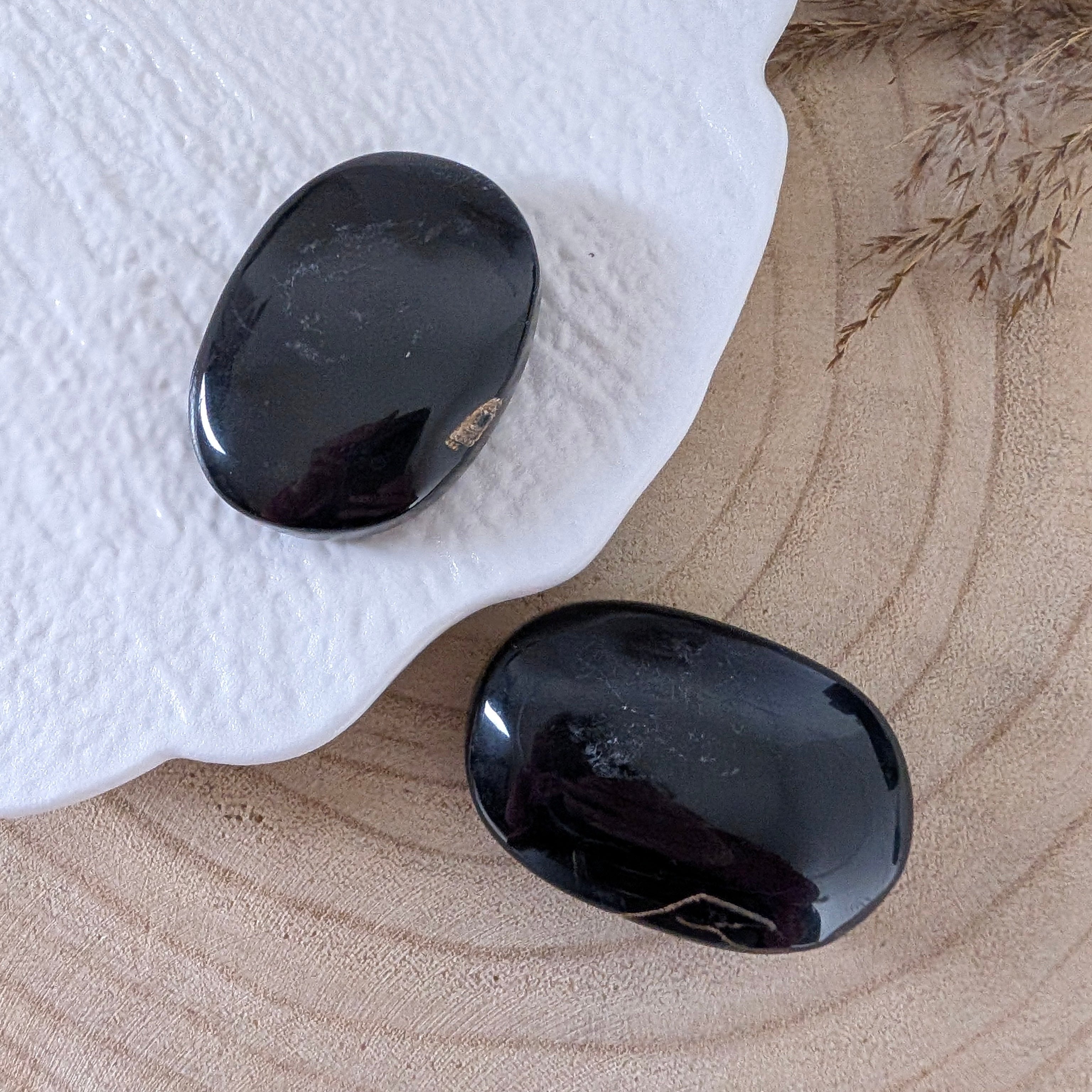 Blauwe tijgeroog palmstenen gepolijst met goudbruine insluitsels op houten ondergrond, afkomstig uit Brazilië.