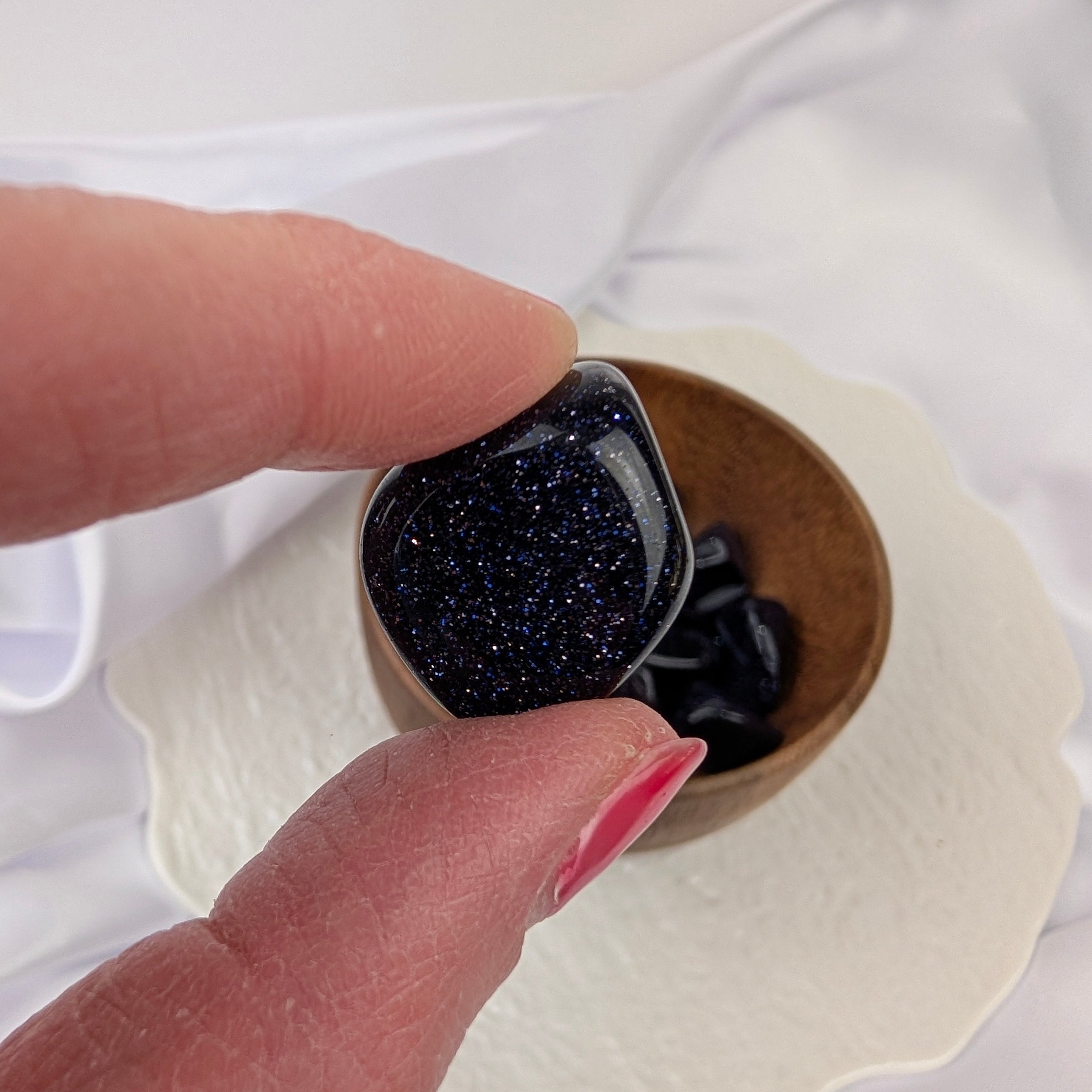Blauwstroom trommelsteen met blauwe glinsteringen in de hand