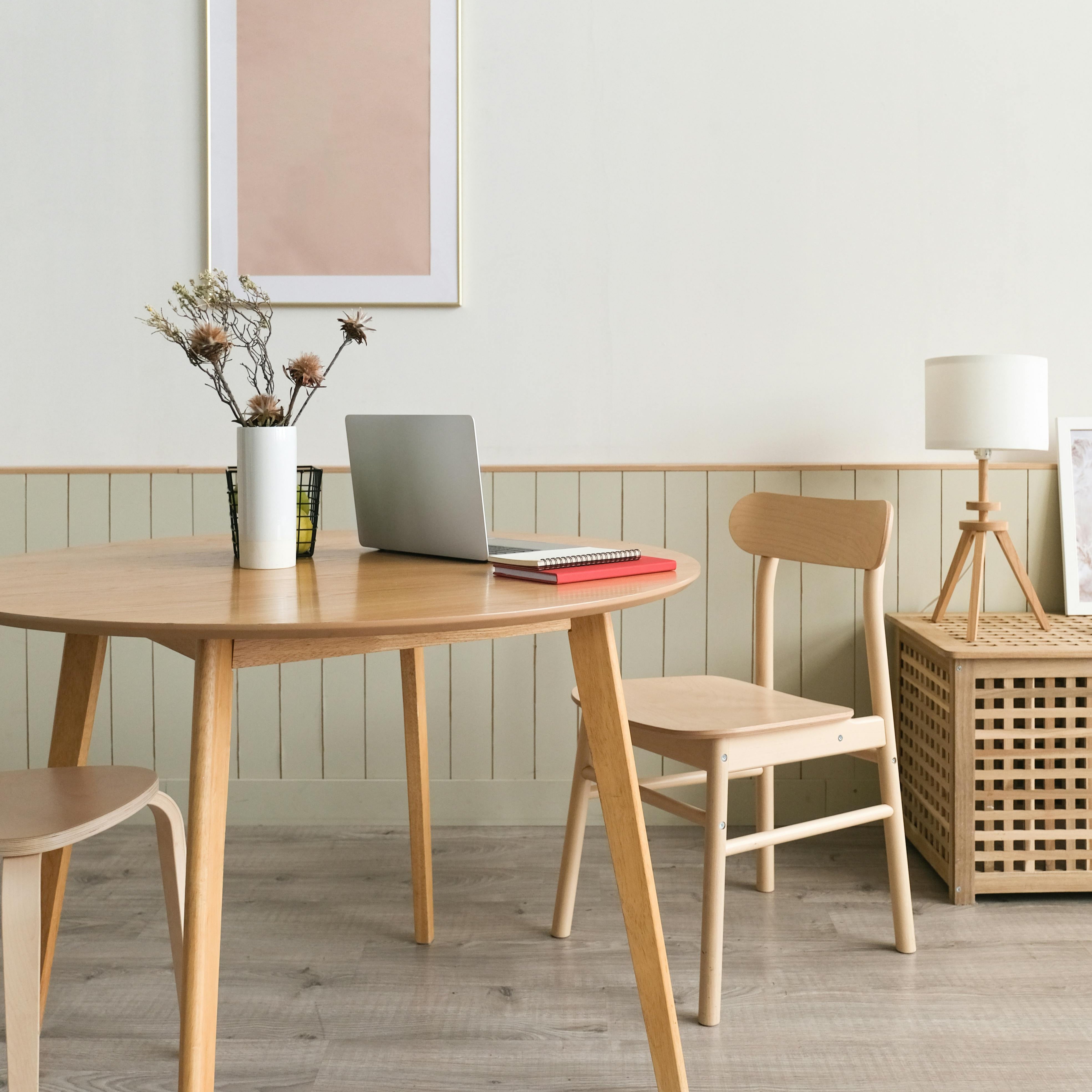 Rustige werkplek met houten tafel, open laptop, notitieboek en minimalistische decoratie – ideaal voor coaching op afstand via e-mail.