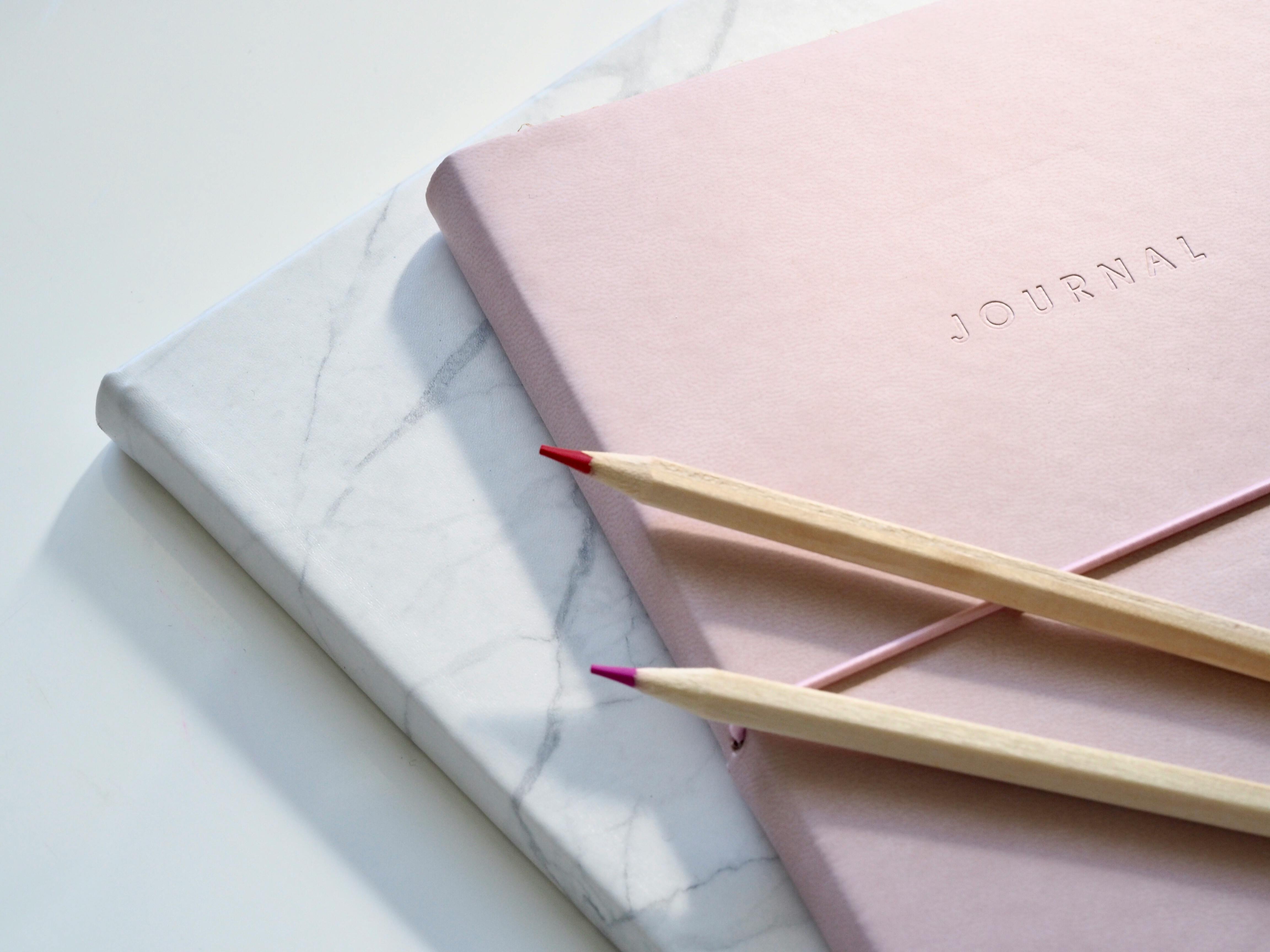 Zachte pastelkleuren met journal en kristallen, symbool voor coaching en persoonlijke groei