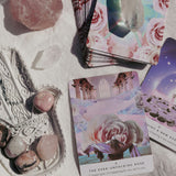 Set tarotkaarten met kristallen en edelstenen op een lichte linnen ondergrond, klaar voor een intuïtieve tarot- en inzichtsessie.