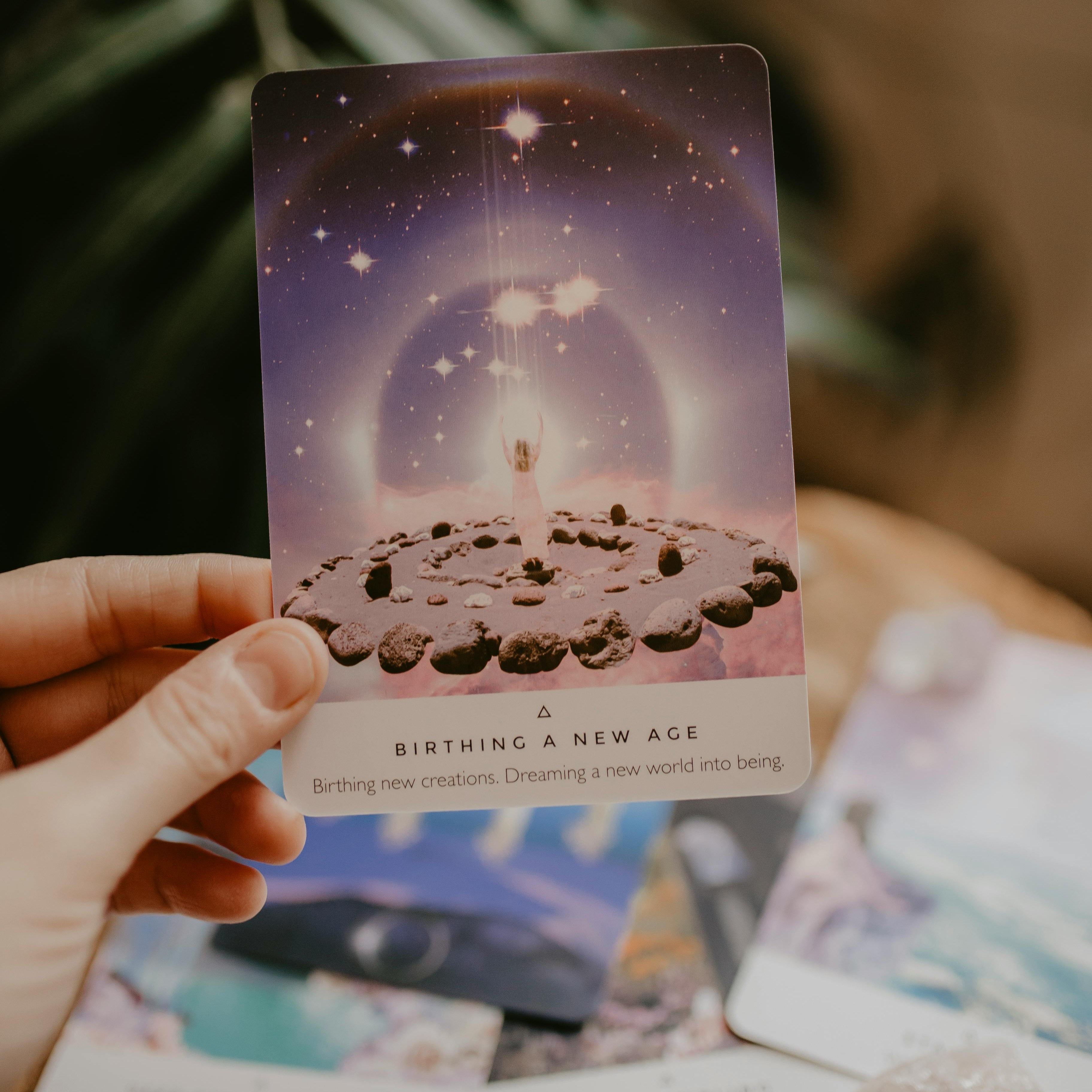 Tarotkaart ‘Birthing a New Age’ voor persoonlijke inzichten en spirituele begeleiding, omringd door kristallen en andere kaarten, ideaal voor online tarot- en inzichtsessies.