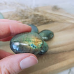 Labradoriet / spectroliet trommelstenen – curated crystal by Marga Jacobs | rust, symboliek en intuïtieve zelfzorg