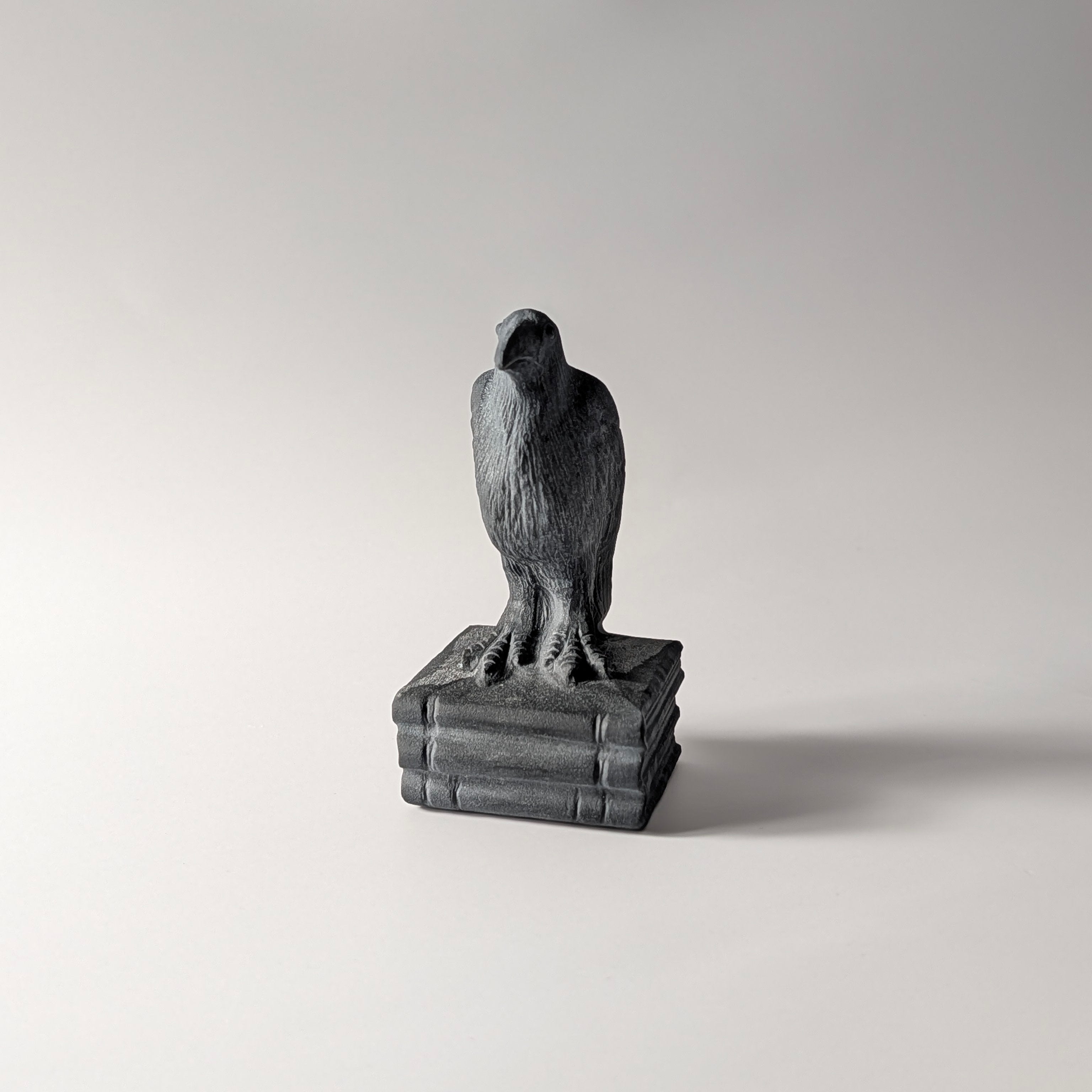 Zwarte obsidiaan raaf op boeken