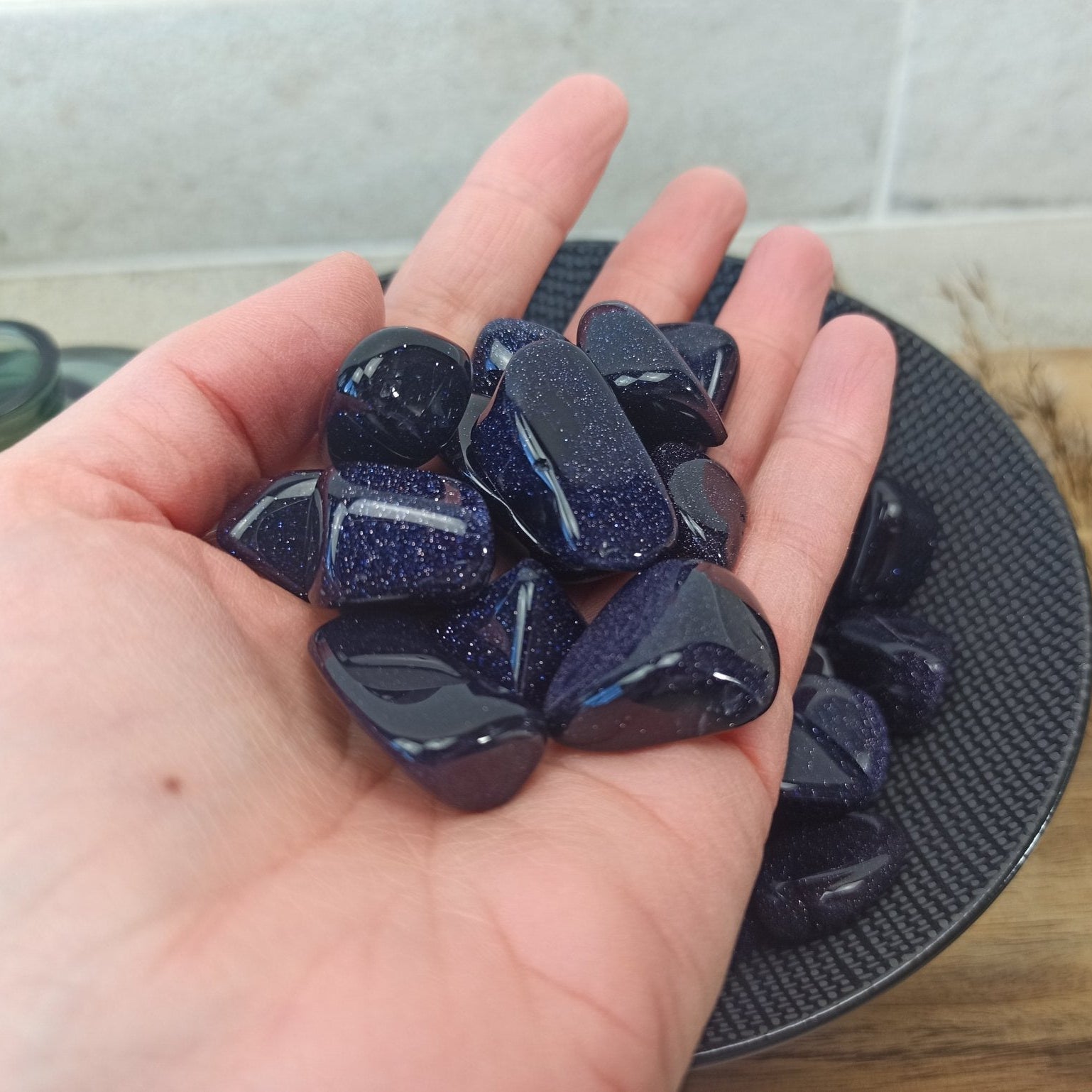 Blauwstroom trommelsteen met blauwe glinsteringen in de hand